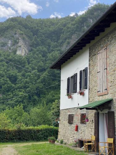 a building with chairs and tables outside of it at Casa Angiolino, angolo di pace vicino all'Orrido di Gea in Villa dʼAiano
