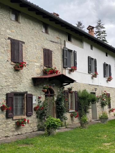 a stone building with flower boxes and windows at Casa Angiolino, angolo di pace vicino all'Orrido di Gea in Villa dʼAiano