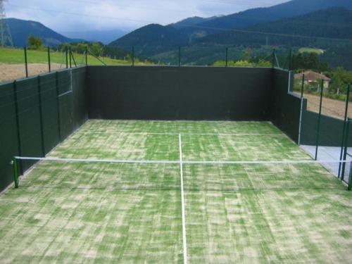 a tennis net on a tennis court with mountains in the background at Casa Rural Garabilla in Santa Coloma
