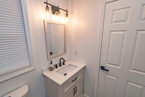 a bathroom with a sink and a mirror and a toilet at Camelback Ski Mts,Firepit, Hottub,Kalahari WaterPark,Linens! in Cresco