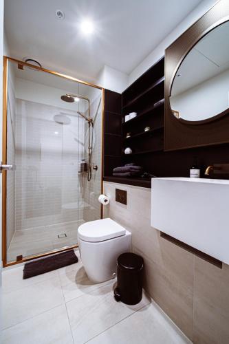 a bathroom with a shower and a toilet and a sink at Metropolitan Muse in Melbourne