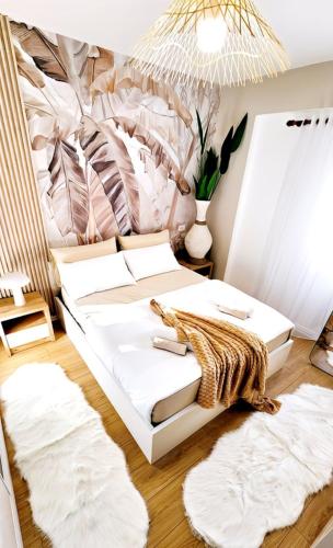 a room with a bed with white pillows and rugs at Premium Beachfront Residences in Durrës