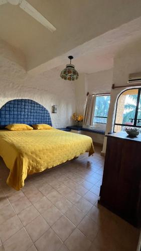 a bedroom with a yellow bed with a blue headboard at Suit Junior Emano 410 in Ixtapa