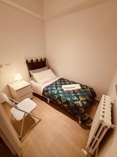 a small bedroom with a bed and a chair at A casa mia in Modena