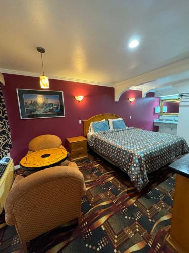 a bedroom with a bed and two chairs and a table at El Dorado Motel in Gardena