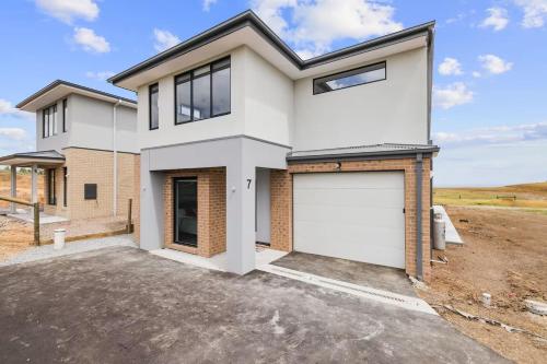 a white house with a garage at Golf Club Mystic Tides by Ready Set Stay in San Remo