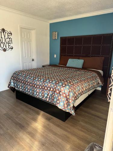 a bedroom with a large bed with a large headboard at El Dorado Motel in Gardena