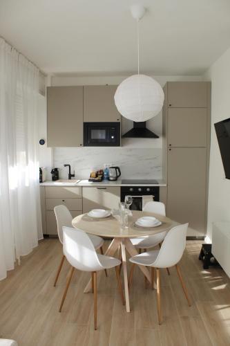 a kitchen with a wooden table and white chairs at NOAcH experience in Livorno