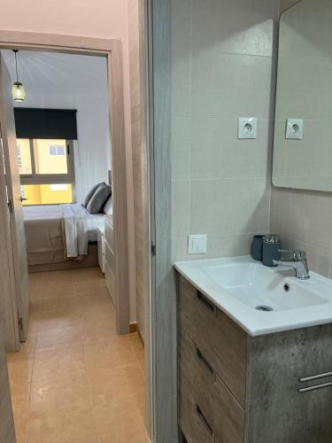 a bathroom with a sink and a mirror and a bedroom at Casa Yanelis in Antigua
