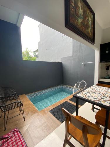 a swimming pool in a room with a table and chairs at Villa Kenangan in Tlekung