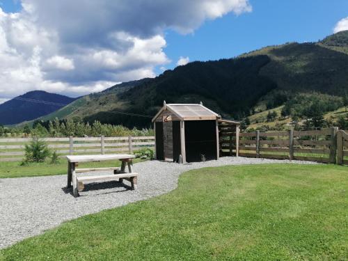 a bench sitting in front of a fence with a shed at Wakamarina off grid retreat in Havelock