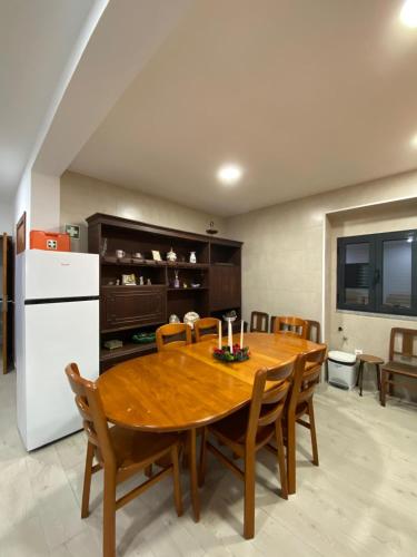 a kitchen with a wooden table and a white refrigerator at Casa da Avó Bia in Penhascoso