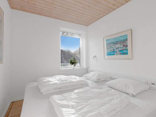 a white bedroom with two beds and a window at Luxury Retreat in Lokken - By Traum Ferienwohnungen in Løkken