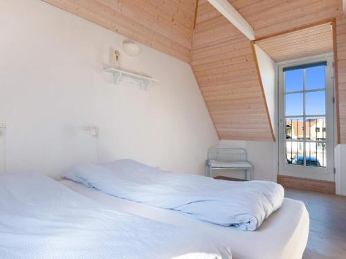 a bedroom with two white beds and a window at Cozy Coastal Retreat - By Traum Ferienwohnungen in Løkken