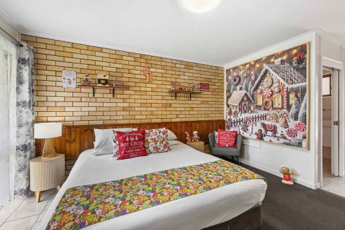 a bedroom with a large bed and a painting on the wall at Motel Glenworth in Toowoomba