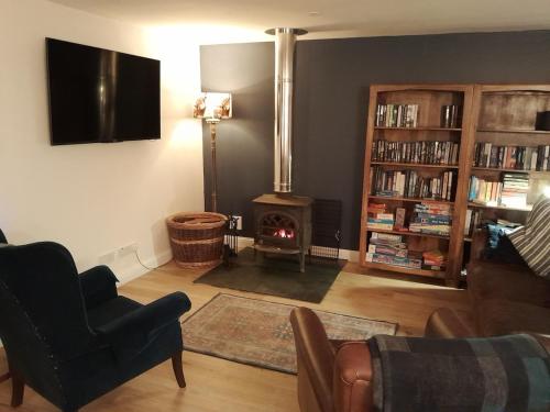 a living room with a fireplace and a fire place at Wee Blue Hoose in Dalmally