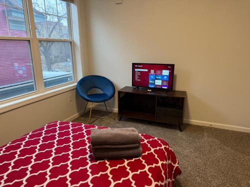 a bedroom with a bed and a tv and a chair at Aldrich Oasis in Minneapolis