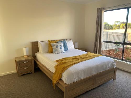 a bedroom with a large bed with a window at Seaview on Terry Court in Kingscote