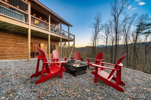 a group of red chairs around a fire pit in front of a house at 4br Cabin In Sevierville Mountain Views, Hot Tub in Pigeon Forge