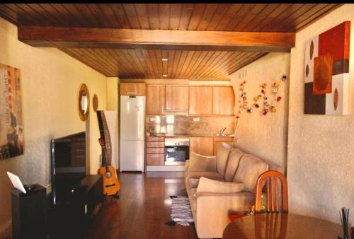 un salon avec un canapé et une cuisine dans l'établissement Apto Pirineos Osseja, à Palau-de-Cerdagne