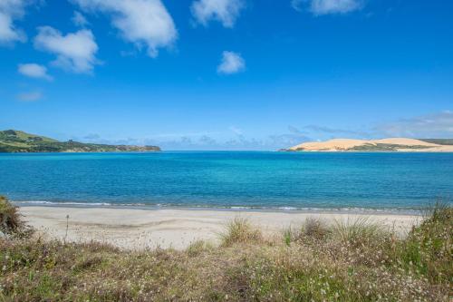 a beach with a large body of water at Kotare Retreat - Omapere Holiday Home in Kaikohe