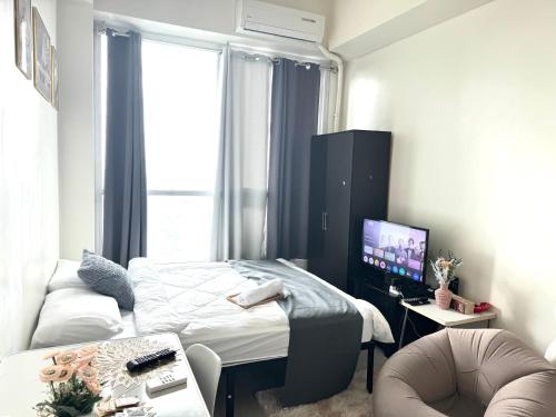 a small room with a bed and a tv at The Wild Roces Makati, The Beacon Residences in Manila