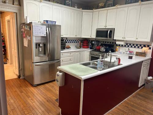a kitchen with white cabinets and a stainless steel refrigerator at Main Oak Manor in Gallipolis