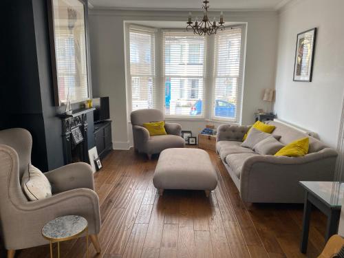a living room with a couch and chairs and a table at Poets Place - lovely 4 bedroom townhouse with garden in Brighton & Hove
