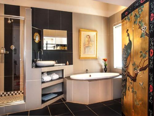 uma casa de banho com uma banheira grande e um lavatório em Sorgvry - House of Guests em Barrydale