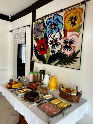 a table with a buffet of food on it at Pousada Vitória Régia - Hotel Costeira in São Sebastião