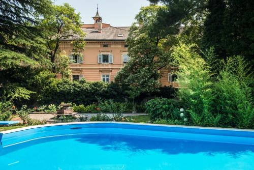 uma grande piscina azul em frente a um edifício em Hotel Elephant em Bressanone