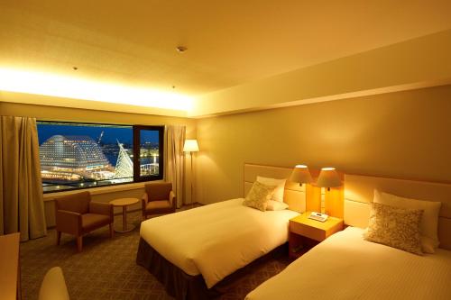 a hotel room with two beds and a window at Hotel Okura Kobe in Kobe