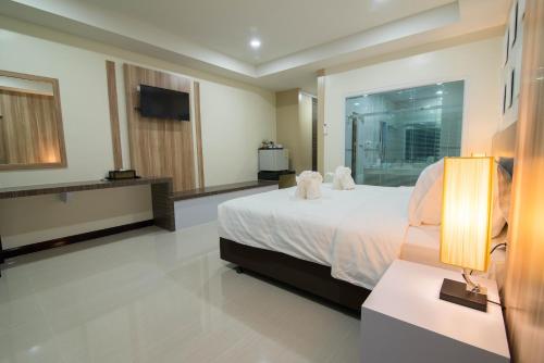 a hotel room with a bed and a television at Som-O House Hotel in Nakhon Ratchasima