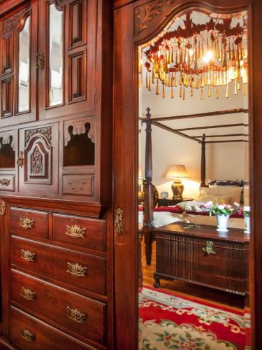 a bedroom with a bed and a dresser and a chandelier at Sorgvry - House of Guests in Barrydale