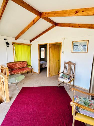 a living room with a red rug and a couch at Cabañas Las Parvas by Samtours in Puerto Tranquilo