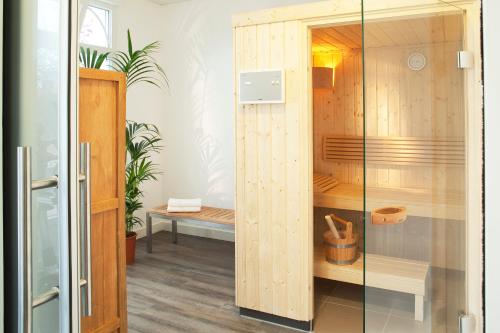 a wooden cabinet with a glass door in a room at Hotel Le Bugatti in Molsheim
