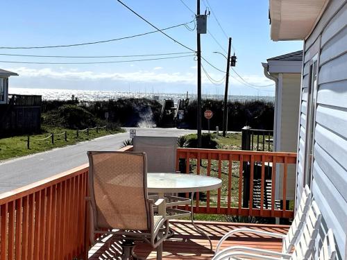 a patio with a table and chairs on a balcony at A Drunken Parrots Beach Side Paradise in North Topsail Beach