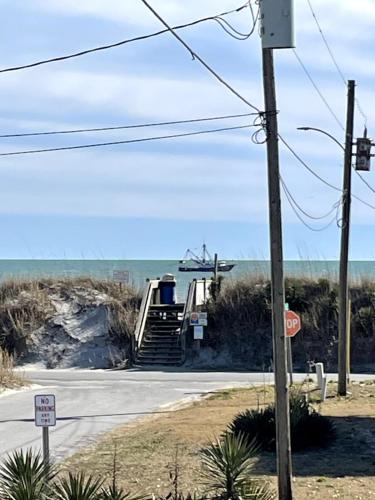 a road with a staircase leading down to the ocean at A Drunken Parrots Beach Side Paradise in North Topsail Beach