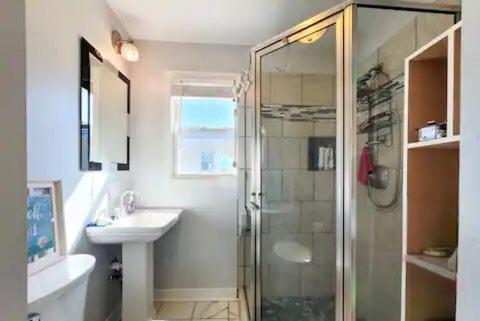 a bathroom with a shower and a sink at A Drunken Parrots Beach Side Paradise in North Topsail Beach