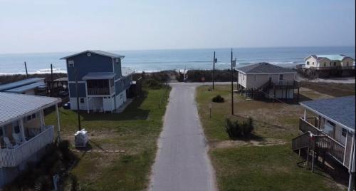 an empty road between houses and the ocean at A Drunken Parrots Beach Side Paradise in North Topsail Beach