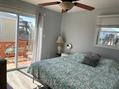 a bedroom with a bed and a ceiling fan at A Drunken Parrots Beach Side Paradise in North Topsail Beach