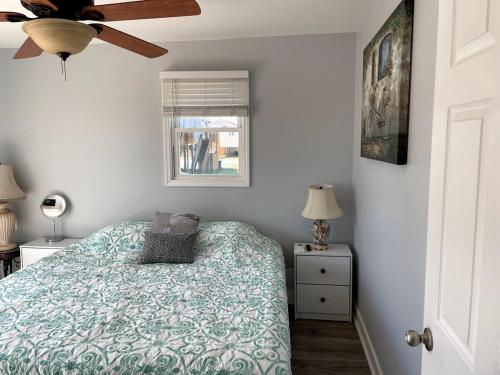 a bedroom with a bed and a ceiling fan at A Drunken Parrots Beach Side Paradise in North Topsail Beach