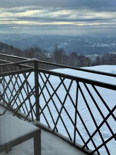 a snow covered balcony with a bench in the snow at Grand Elegant & SPA in Kopaonik