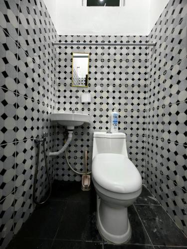 a bathroom with a white toilet and a sink at Tanjong Suite Homestay in Kampong Tok Pakir