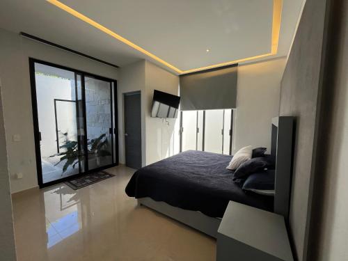 une chambre avec un lit et une grande fenêtre dans l'établissement Casa Privada Acapulco, à Acapulco