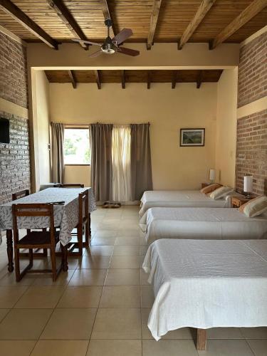 a room with four beds and a table at Luna y Cumbres in Cafayate