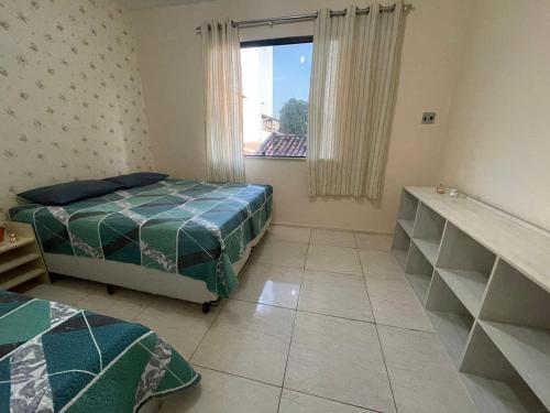 a bedroom with two beds and a window at Green House in Aracaju
