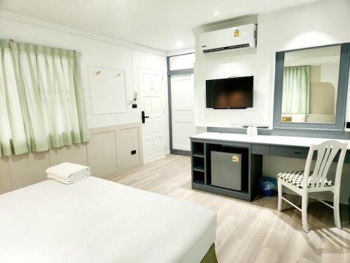 a room with a bed and a desk and a sink at SEATEL Phuket, Patong Beach in Patong Beach