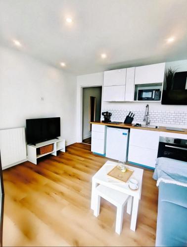 - un salon avec des armoires blanches et une table dans l'établissement Élégant appartement - 18 min de Paris Cathédrale notre-dame, à Choisy-le-Roi