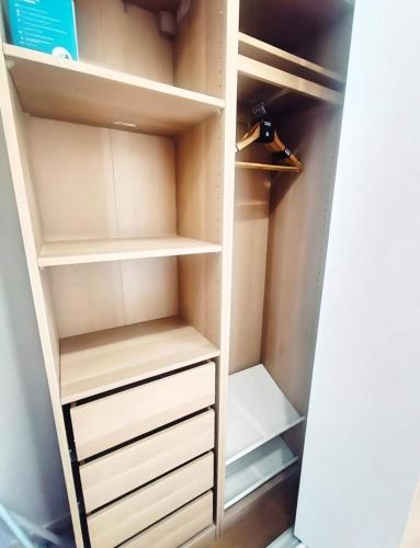 un placard avec des étagères et des tiroirs blancs dans l'établissement Élégant appartement - 18 min de Paris Cathédrale notre-dame, à Choisy-le-Roi